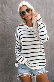 Relaxed white and black striped knit pullover sweater with crew neck and long sleeves.