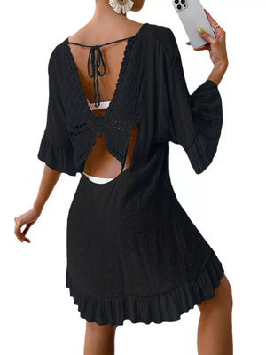 Black cover-up dress with crochet back detail, bell sleeves, and ruffled hem.