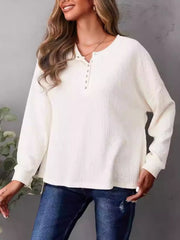 Ivory waffle knit henley shirt with side slits and button detail.