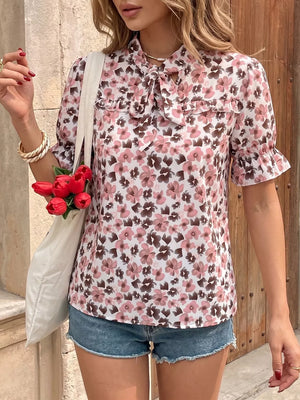 Floral tie-neck ruffle shirt with short puff sleeves and a frill detail.