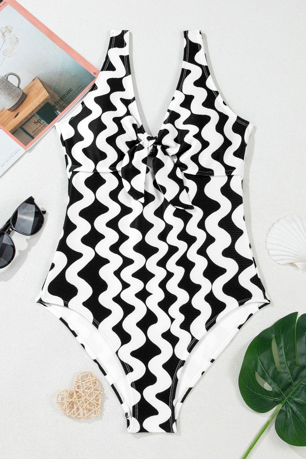 Black and white wave print one-piece swimsuit with a bow-front neckline