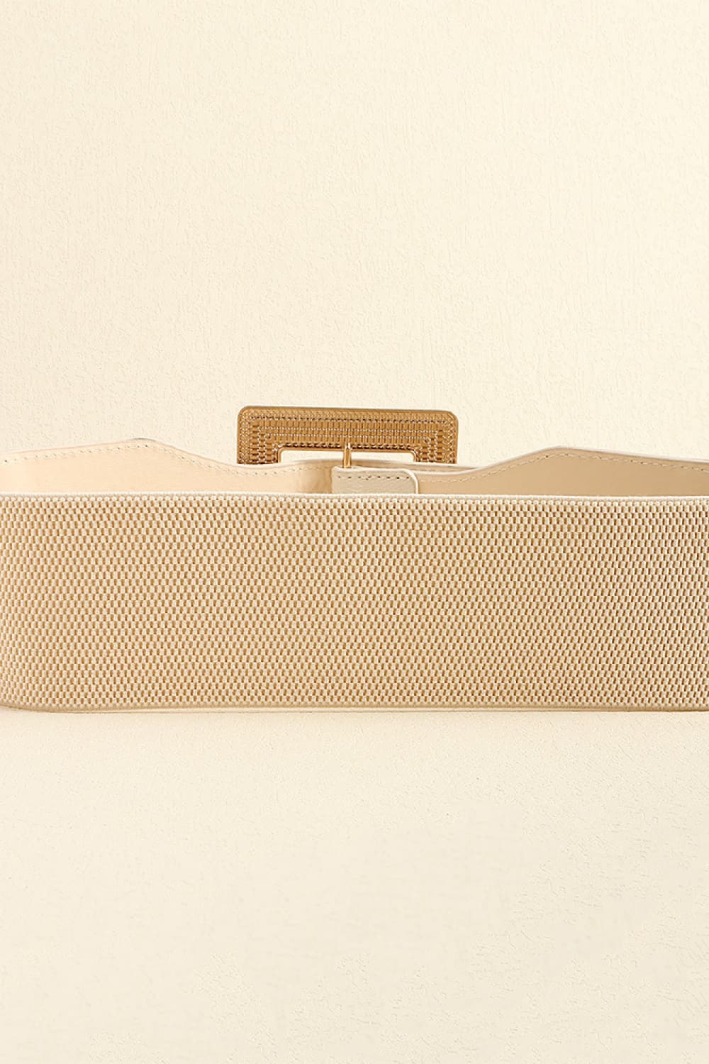 Textured buckle elasticated waist belt in ivory with gold-tone hardware.