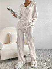 Off-white ribbed knit V-neck loungewear set with long sleeves and wide-leg pants.