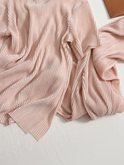 Elegant pink pleated two-piece set with a flowing drape and textured fabric.