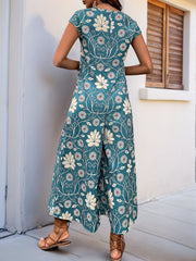 Turquoise botanical print culotte jumpsuit with short sleeves and wide legs.