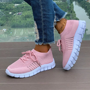 Pink knit runner sneakers with white soles and stripe detail.