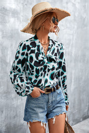 Abstract print blouse with pussy bow and balloon sleeves, in white with black and teal abstract shapes.