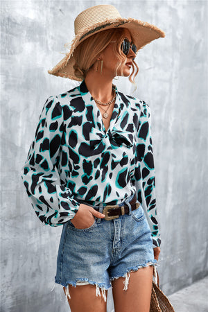 Abstract print blouse with pussy bow and balloon sleeves, in white with black and teal abstract shapes.