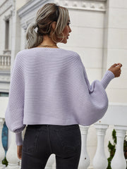 Purple ribbed dolman knit sweater with boat neck and wide sleeves, styled with jeans.