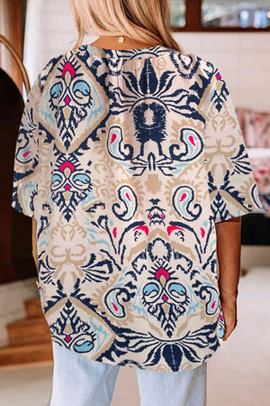 Paisley print blouse in ivory with slit sleeves and a V-neckline.