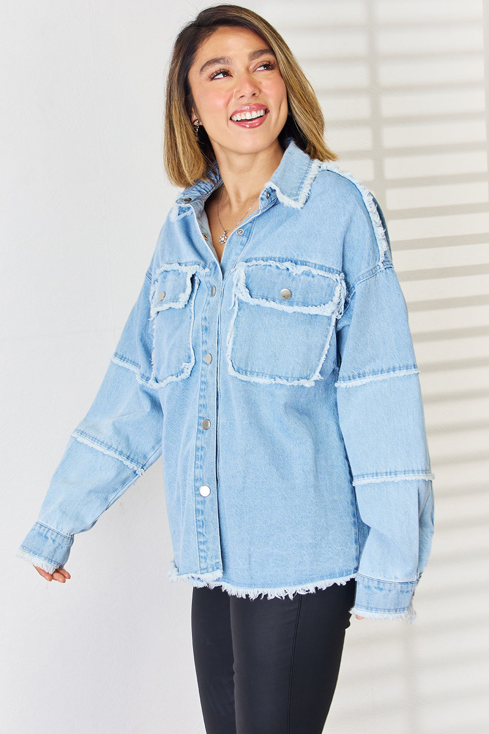 Light wash denim overshirt with patchwork details and frayed edges.