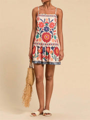 Playful printed mini dress with spaghetti straps, square neck, and tiered hem. Multicolor floral pattern.