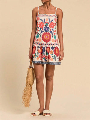 Playful printed mini dress with spaghetti straps, square neck, and tiered hem. Multicolor floral pattern.