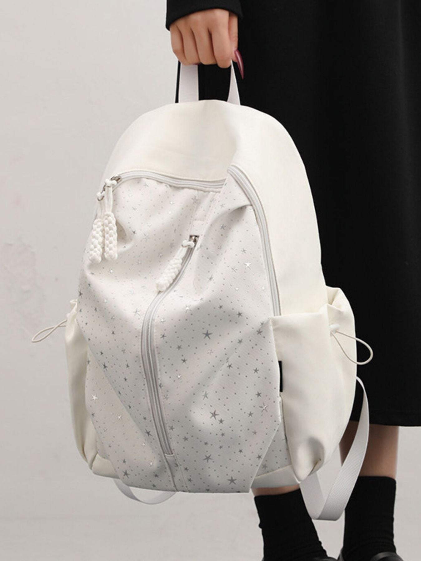 Gray/white nylon school backpack with all-over star pattern and braided zipper pulls.