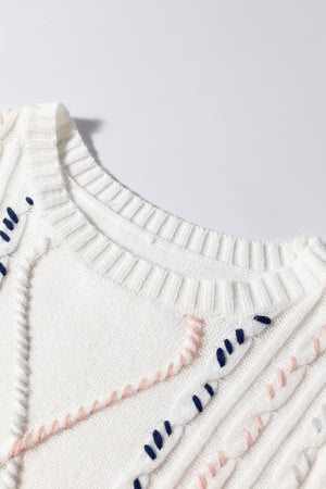 White cable knit sweater with embroidered details and puff sleeves.