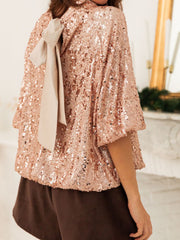 Dazzling sequin blouse in ochre with a tie-back detail and bell sleeves.
