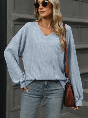Light blue ribbed v-neck top with blouson sleeves and a relaxed fit.
