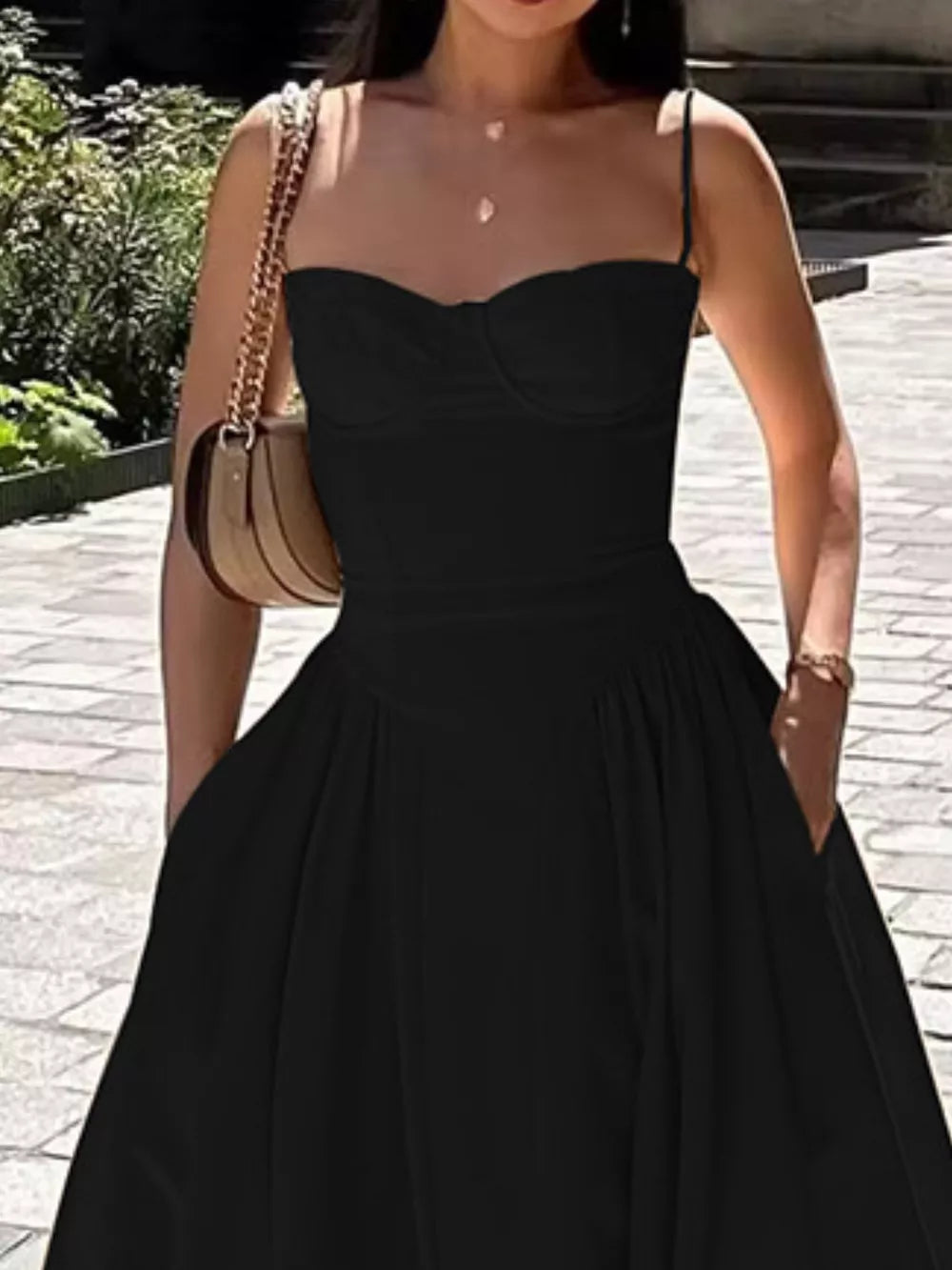 Black sweetheart midi dress with spaghetti straps and a full skirt.