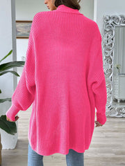 Pearl button ribbed knit cardigan in bright pink acrylic with a relaxed fit and long sleeves.