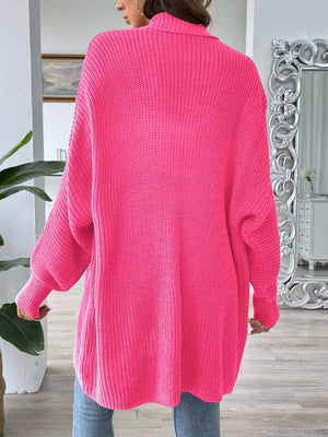 Pearl button ribbed knit cardigan in bright pink acrylic with a relaxed fit and long sleeves.