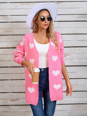 Pink acrylic cardigan with white intarsia hearts, long sleeves, open front, and relaxed fit.