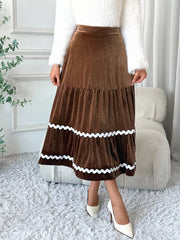 Brown velvet tiered midi skirt with wavy white trim and a-line cut.