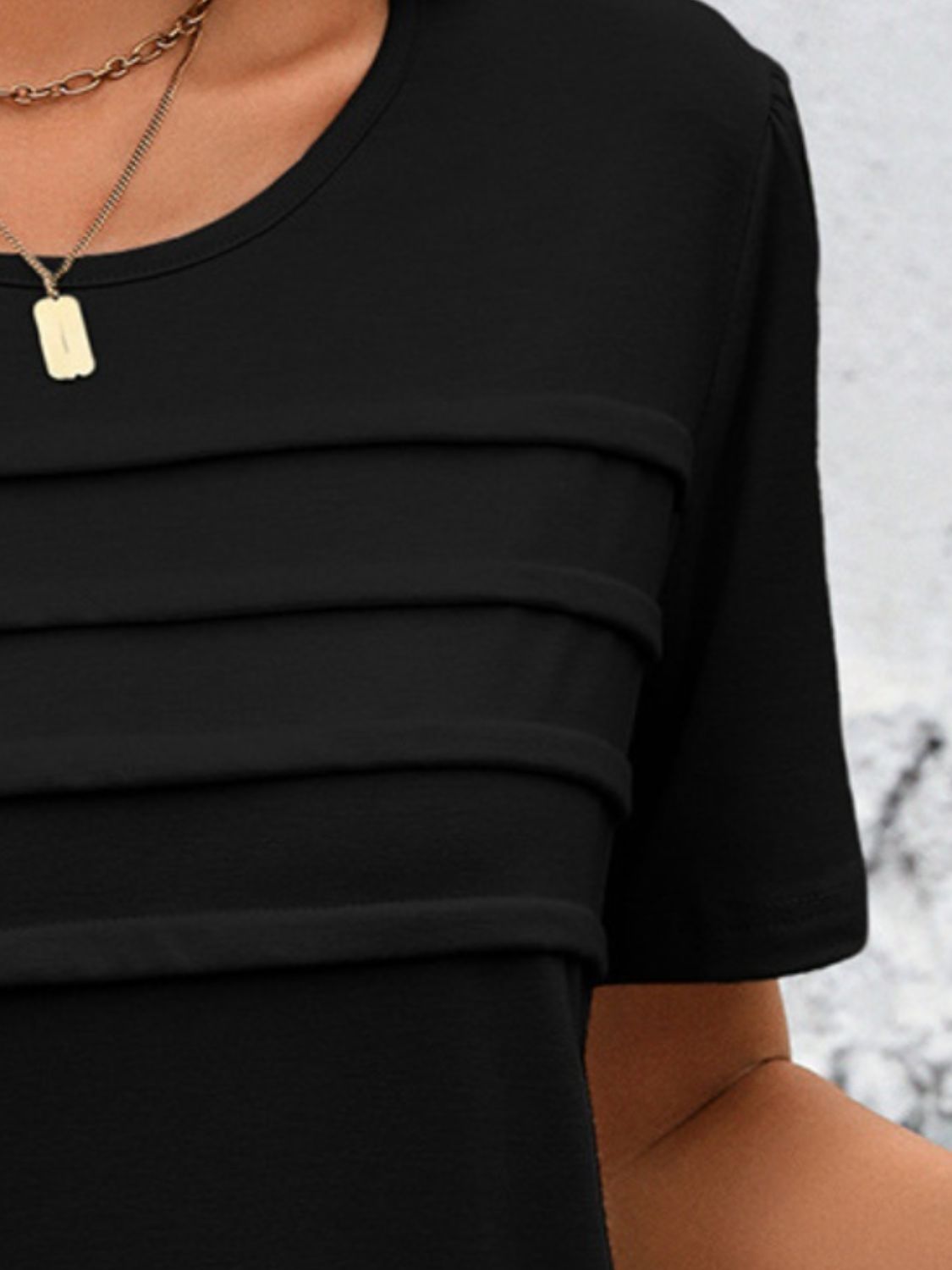 Black jersey top with horizontal pleats on the bodice and crew neck.