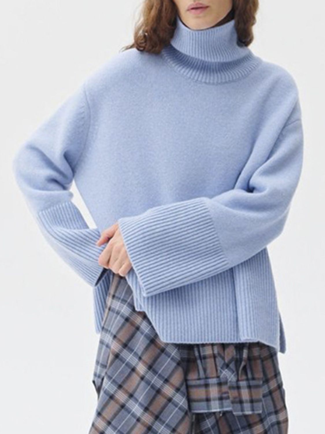 Light blue ribbed turtleneck sweater with flared sleeves and a ribbed cuff detail.