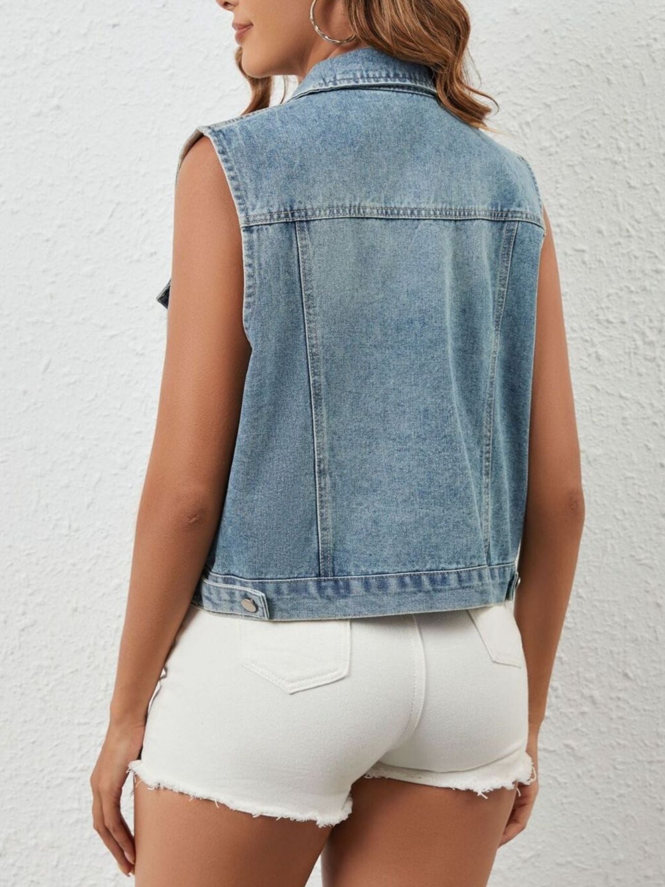 Sleeveless denim vest with rhinestone embellishments, button-down front, and collar.
