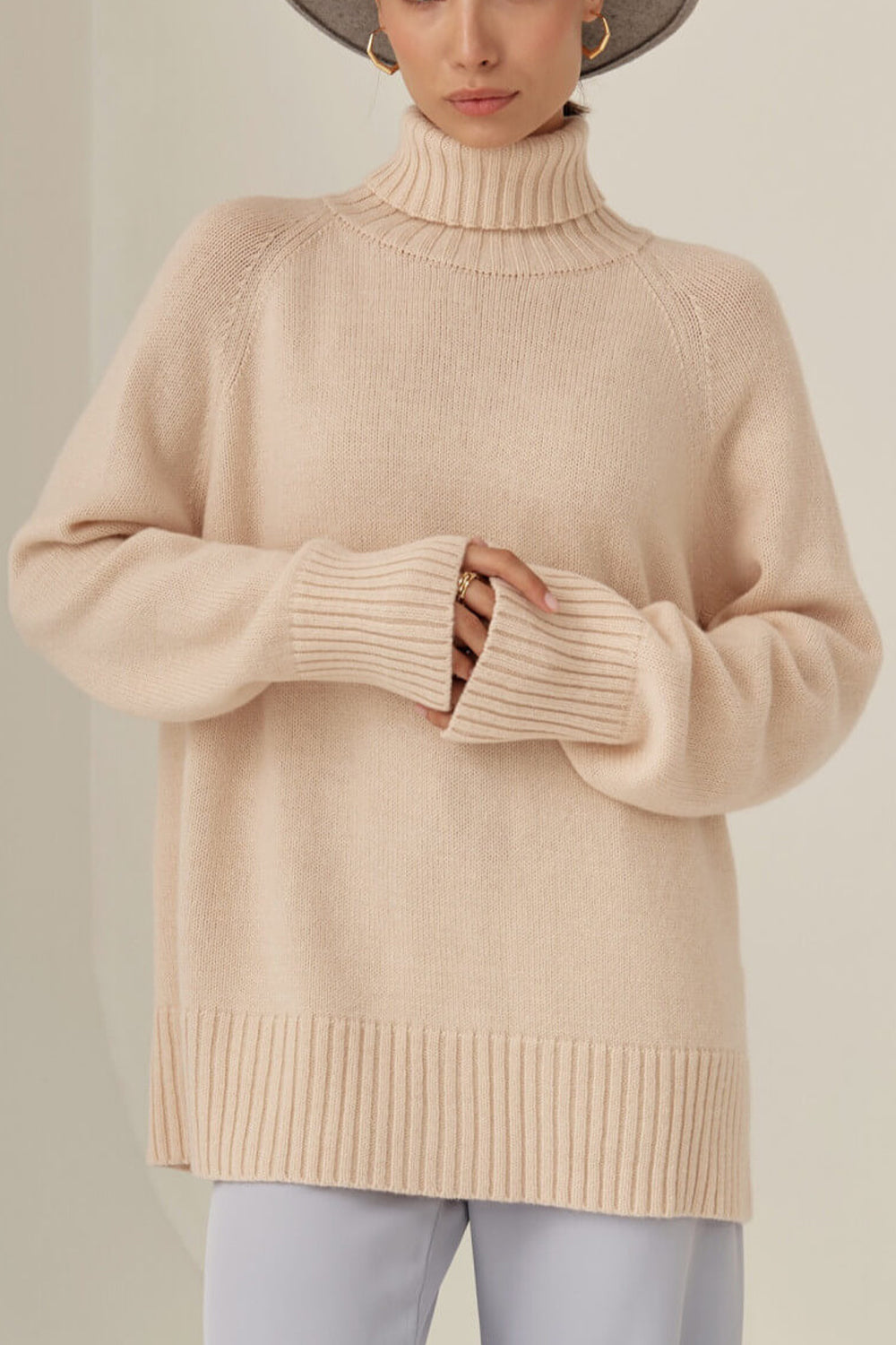 Blush pink cashmere turtleneck sweater with raglan sleeves and ribbed cuffs and hem.