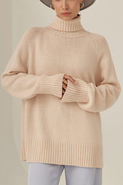 Blush pink cashmere turtleneck sweater with raglan sleeves and ribbed cuffs and hem.
