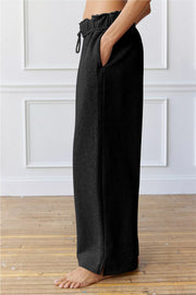 Black relaxed palazzo lounge trousers with drawstring waist and side pockets.