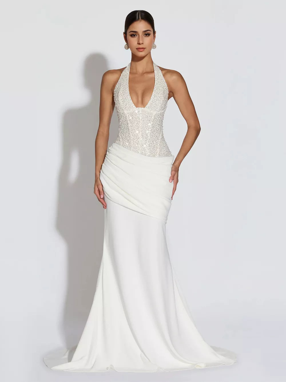 White sequin halter neck maxi gown with draped skirt and train.