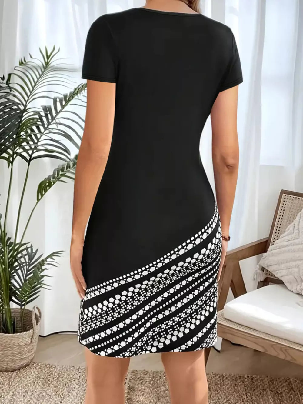 Black bodycon mini dress with geometric print detail on the hem