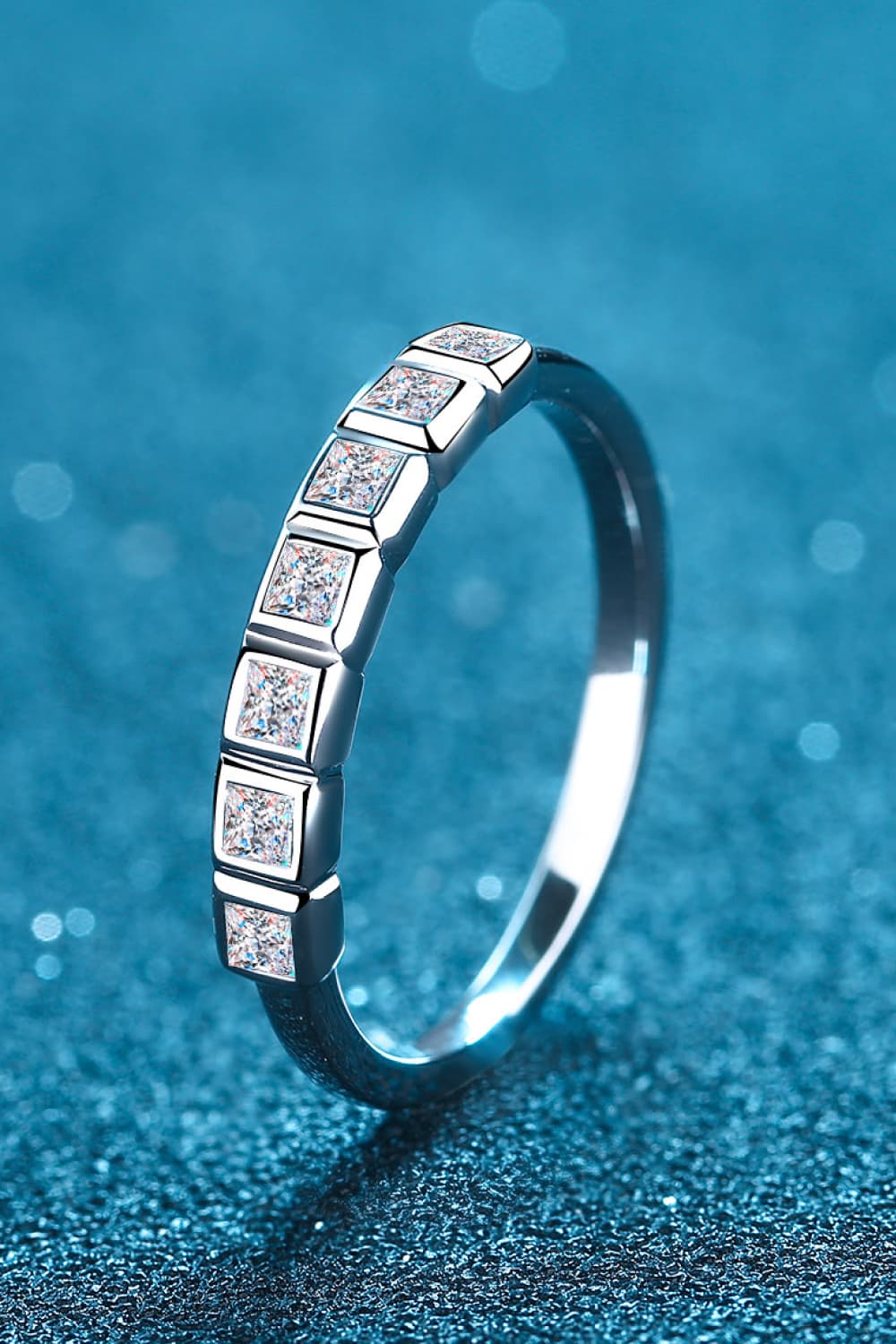 Silver band ring with princess cut diamonds in square settings