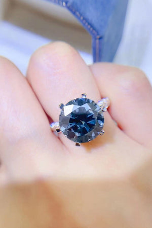Midnight blue solitaire engagement ring with a large round gemstone and diamond band.