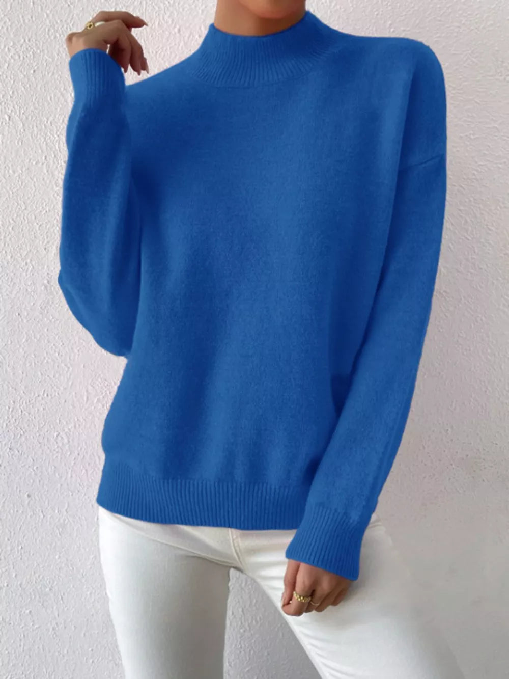 Blue mock neck knit sweater with dropped shoulders and ribbed cuffs and hem.