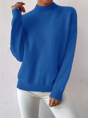 Blue mock neck knit sweater with dropped shoulders and ribbed cuffs and hem.
