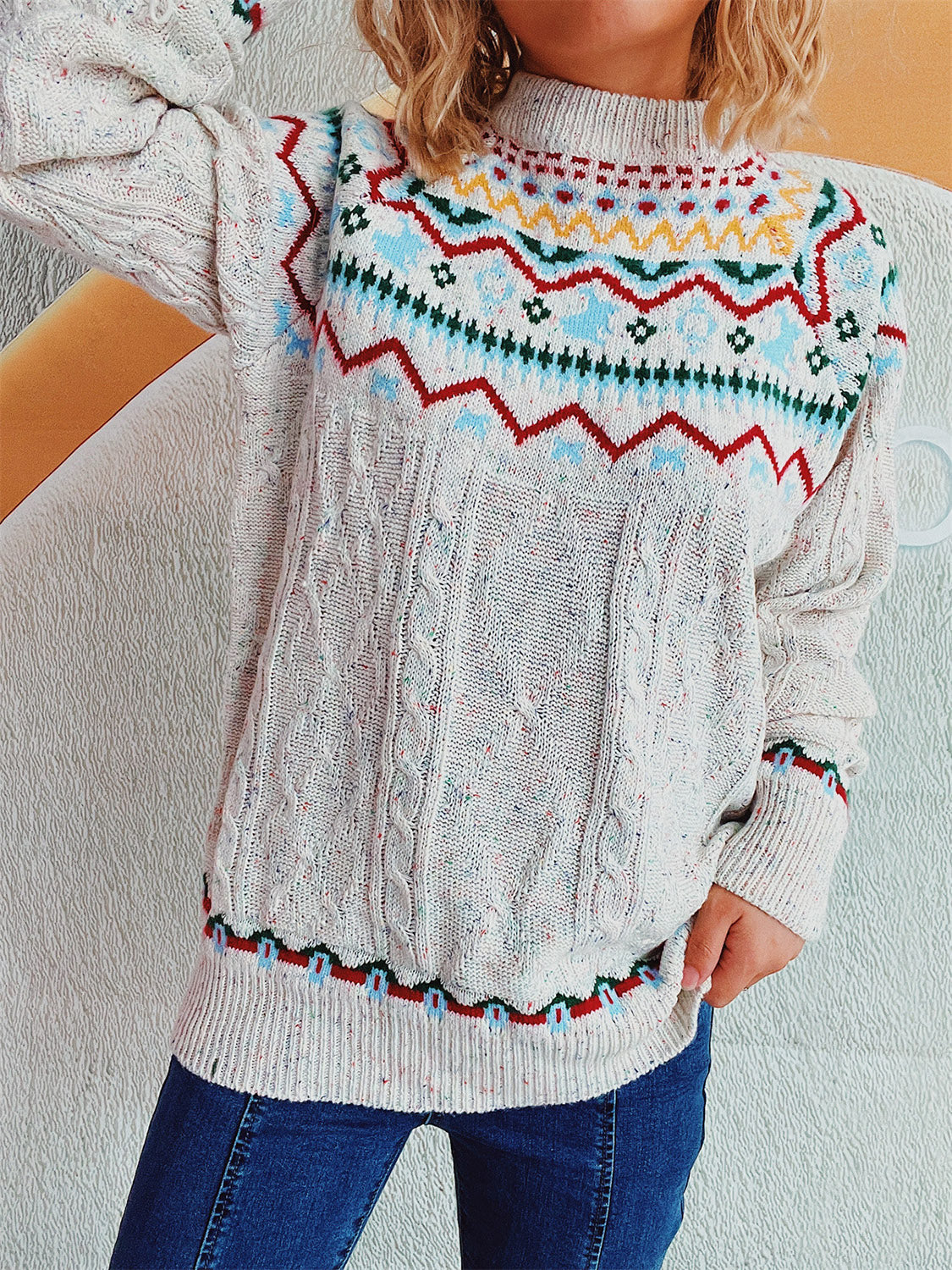Beige cable knit turtleneck sweater with Fair Isle pattern and flecks of color.