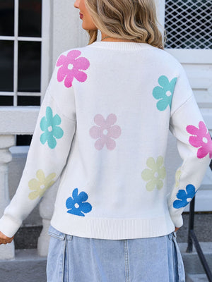 White crewneck sweater with a pastel floral print and ribbed cuffs and hem.
