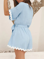 Blue linen romper with scalloped edges and tie waist, short sleeves