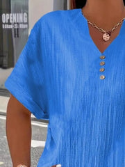 Blue textured v-neck t-shirt with decorative buttons and short sleeves.