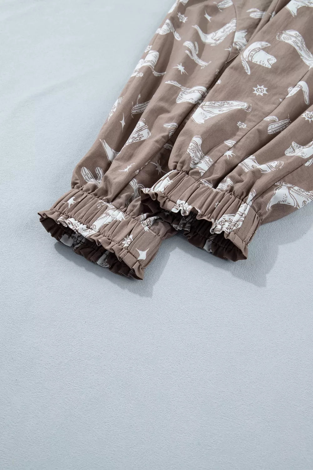Brown cotton joggers with white western print and ruffled elastic cuffs.
