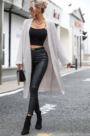 Longline knit cardigan in light gray with pockets, open front, and ribbed texture.