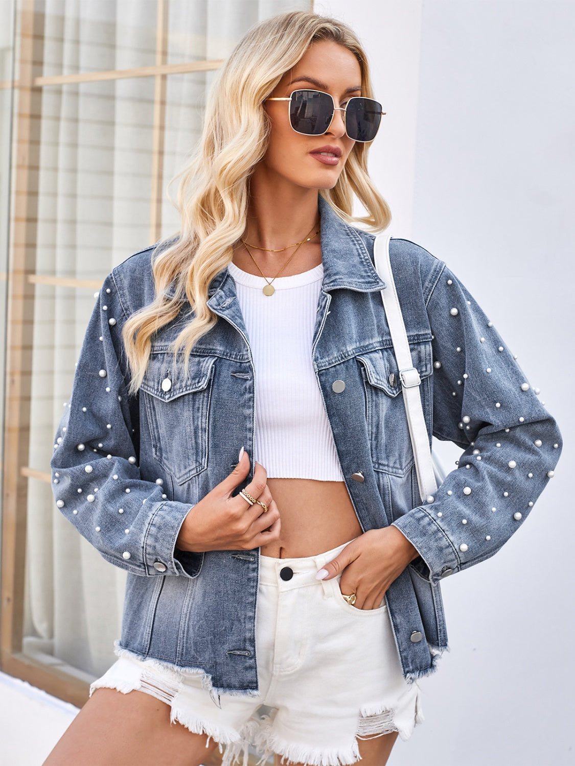 Dusty blue denim jacket with pearl embellishments and button closure.