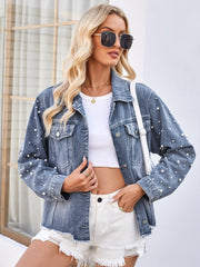 Dusty blue denim jacket with pearl embellishments and button closure.