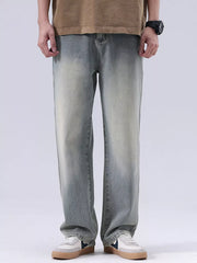 Men's blue vintage wash loose fit cotton jeans with faded details.