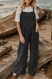 Black textured cotton overalls with square pockets and wide legs, styled with a white tee.
