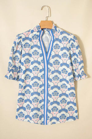 Playful floral puff sleeve blouse with smocked cuffs and neckline, featuring a blue and pink floral pattern.