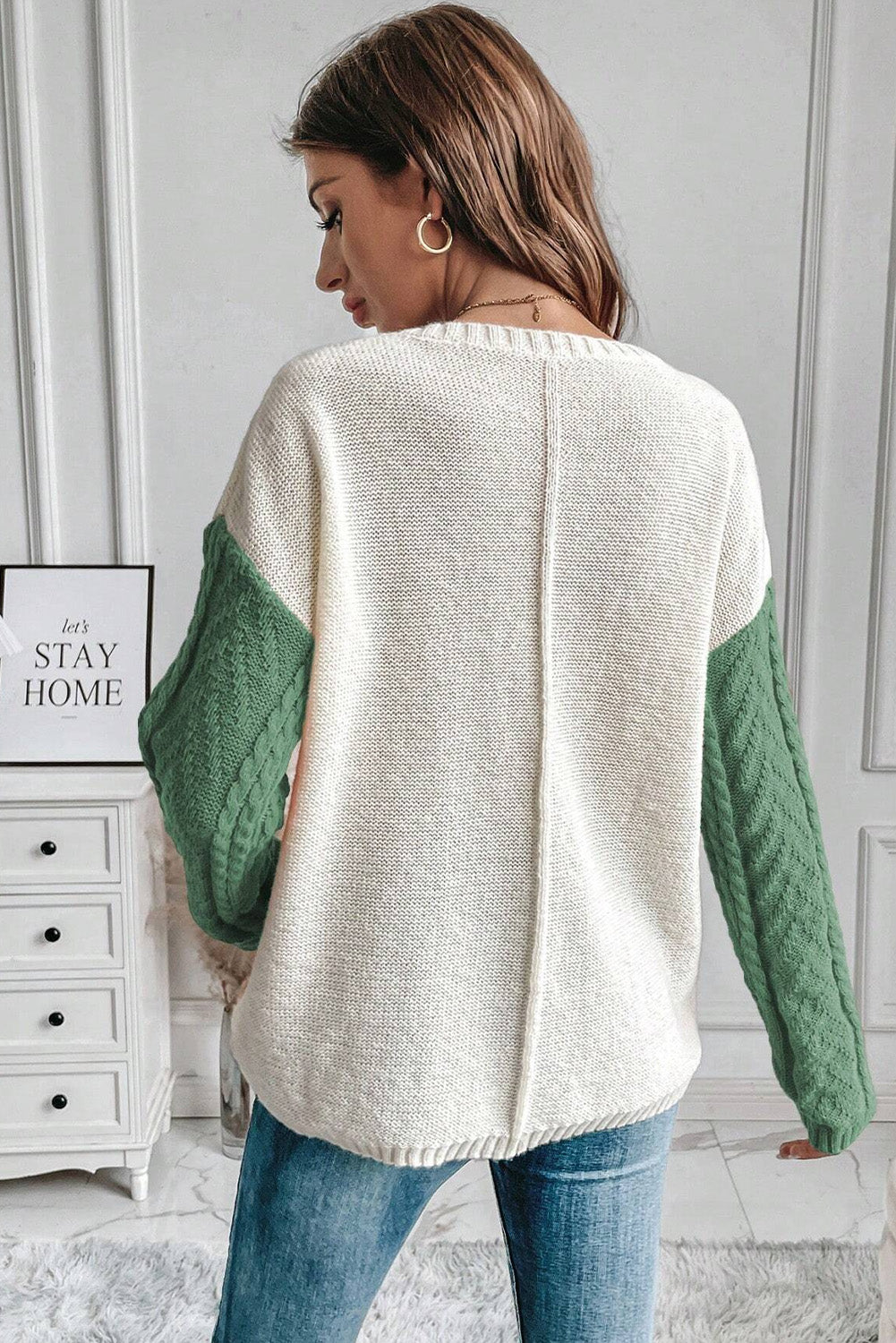 Colorblock cable knit sweater in cream and gum leaf green with textured sleeves.